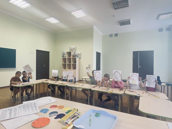Дети с рисунками эмоций